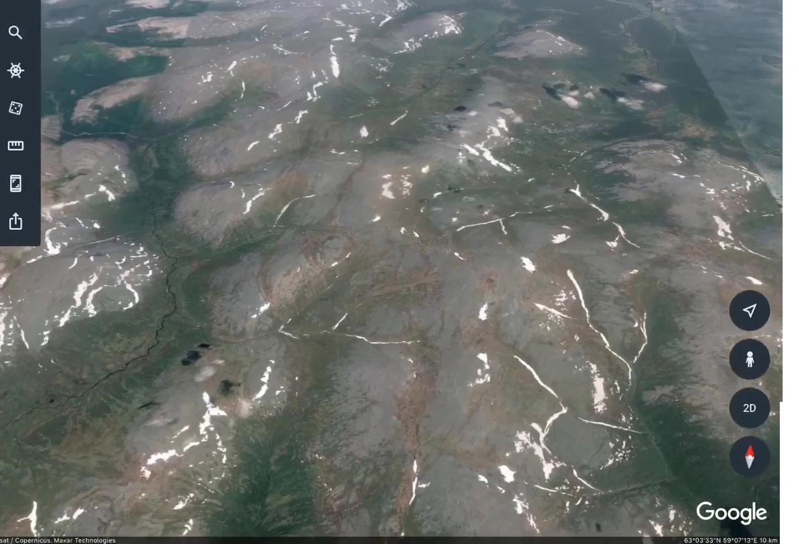 Google Earthで拡大したウラル山脈の画像。灰緑色の丸みを帯びた尾根がいくつも連なり、谷筋には残雪の白い筋が見える。