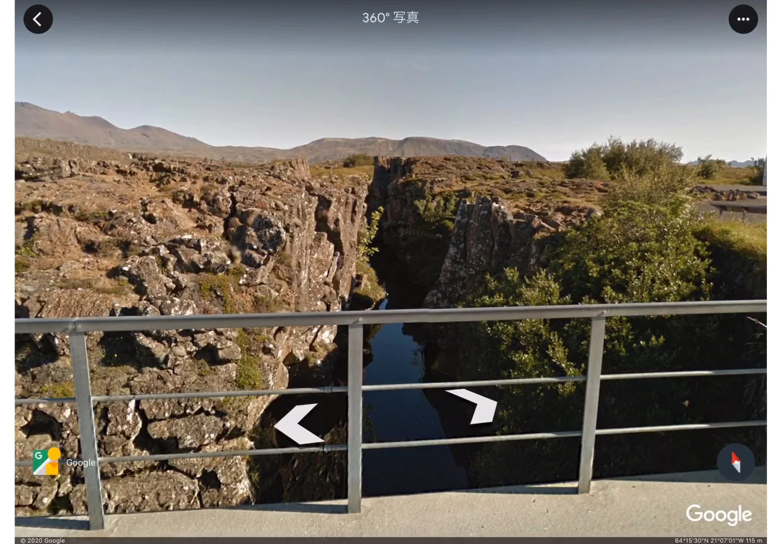 アイスランドのギャオを地上の展望所から撮影した360度写真。手すりの向こうに、岩盤が縦に裂けた深い割れ目が奥へと続き、底には水がたまっている。奥には低い山並みが広がっている。